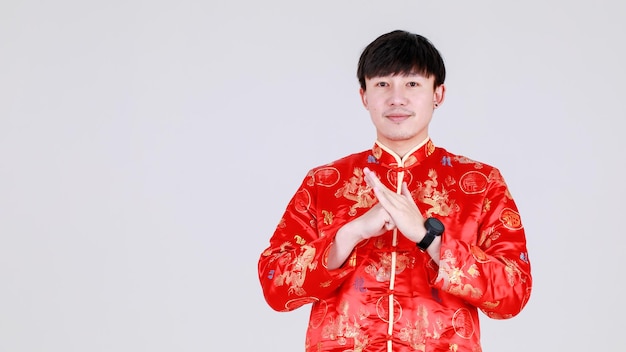 Smart chinese man on elegant red traditional mandarin shirt gesture for warm welcome greeting with respect and bless for healthy and wealth on happy celebration of lunar new year for eastern people.