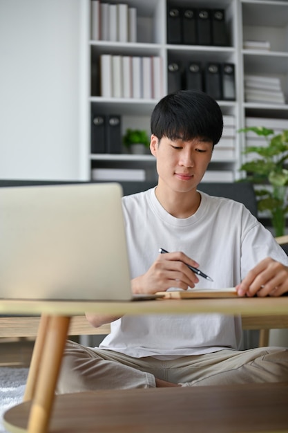 A smart and focused young Asian man is working from home managing his work