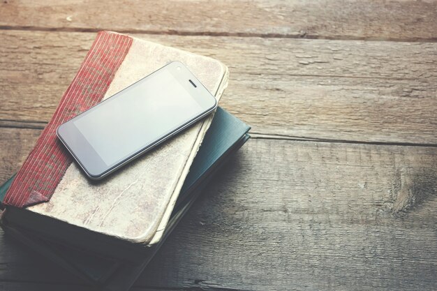 Smart phone white books on the wooden table