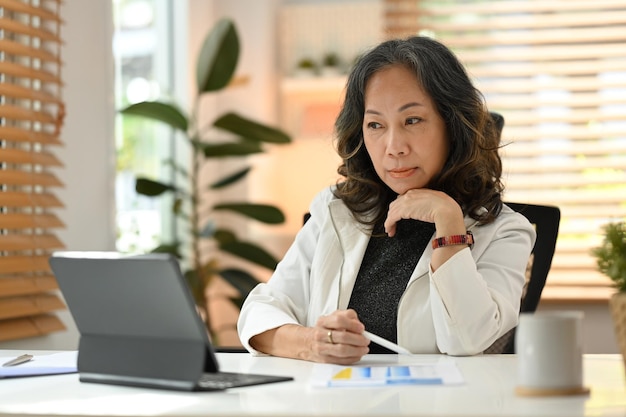 Smart professional senior business woman watching business training online webinar on laptop computer remote working from home