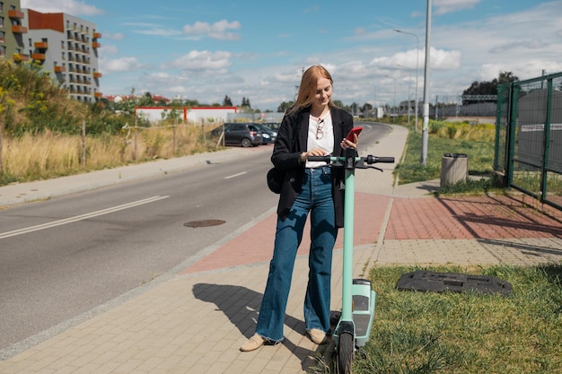 Smart public transport happy young s woman rents an electric scooter unlocking ecofriendly transport