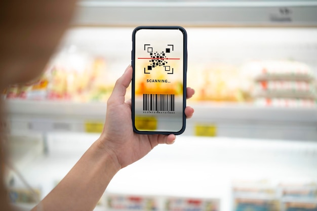 Smart retail conceptFemale hands using barcode scan for information of product in supermarket