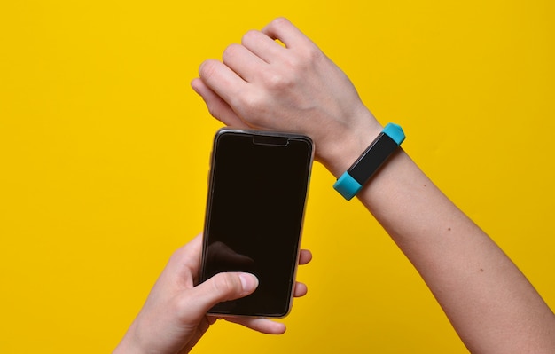 Smart watch on the wrist and a smartphone in the hand synchronization. Fitness bracelet Modern technologies.
