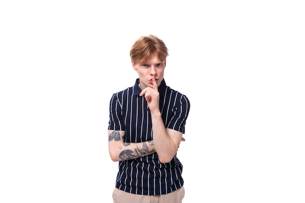 Smart year old blond man with tattoos in a striped polo thinking