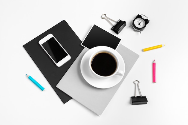 Smartphone and coffee cup with office supplies