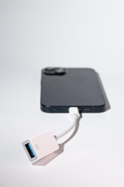 A smartphone connected to a USB adapter for data transfer via a port