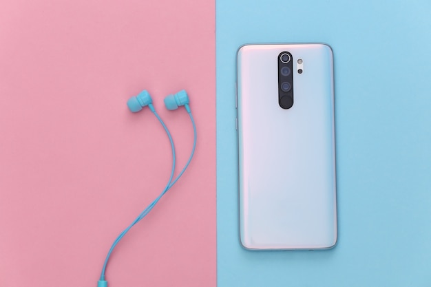 Smartphone and earphones on blue-pink pastel