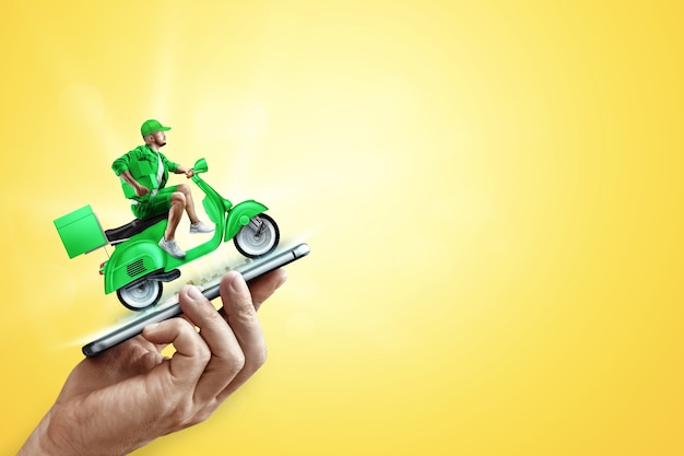 Photo smartphone in hand and fast delivery man on a green scooter. delivery concept, online order, food delivery, last mile, banner, template.