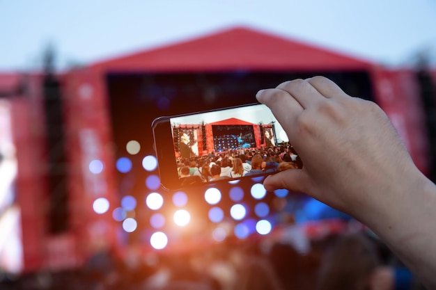 Smartphone in hands during outdoor rock concert