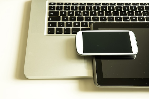 A smartphone, a laptop computer and a Tablet PC together on a desktop.