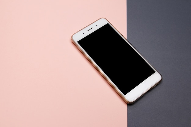 Smartphone or Mobile phone on pink and grey background with copy space. 