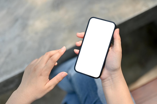 A smartphone mockup is a woman's hand over blurred background