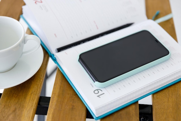 Smartphone and notepad for planning affairs lie on table