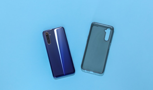 Smartphone and silicone protective cover on blue background. 