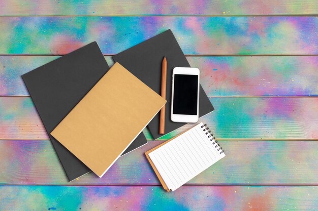 Smartphone, tablet, notebook  pen on the background of a wooden table