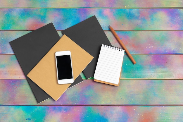 Smartphone, tablet, notebook  pen on the  of a wooden table