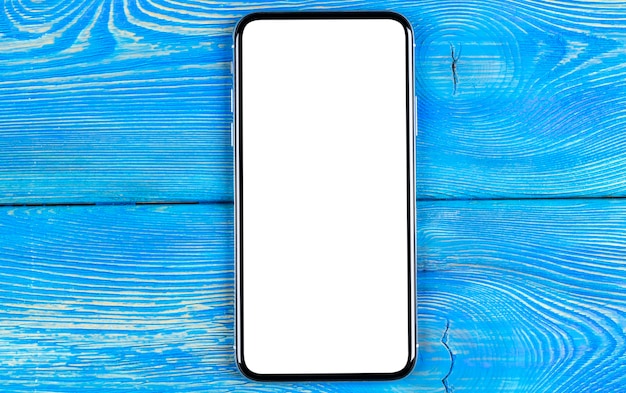 Smartphone with blank screen mock up. Smartphone isolated screen with clipping path. Mobile phone white screen with copy space on office desk. Empty space for text. Isolated white screen