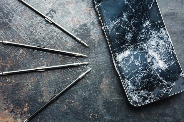 Smartphone with a broken screen and repair tools Closeup