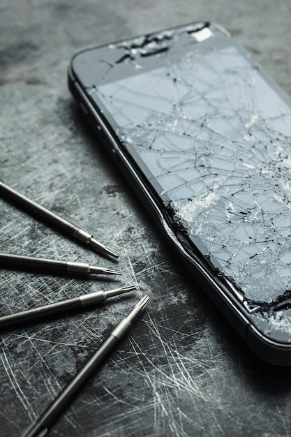 Smartphone with a broken screen and repair tools Closeup