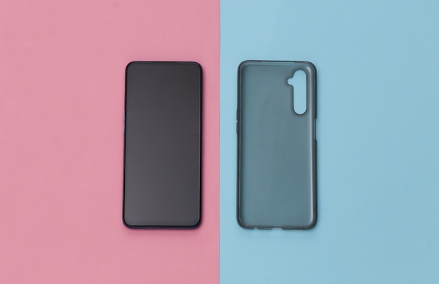 Smartphone with a silicone protective cover on pink blue background. Top view