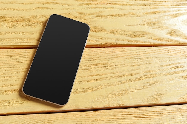 Smartphone on wooden background. Top view