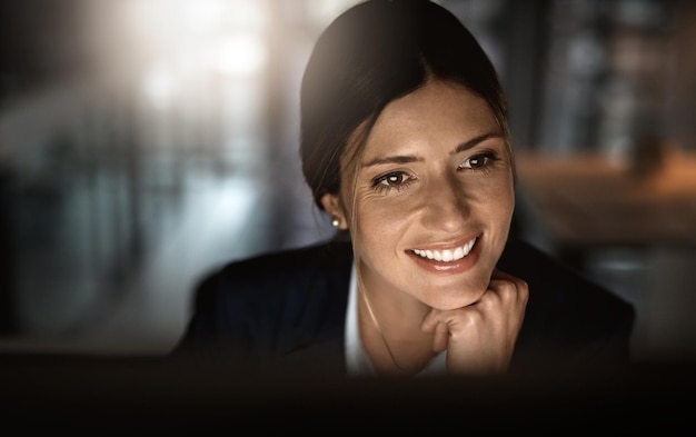 Smashing goals like the pro that she is Shot of a young businesswoman working online during a late night in a modern office