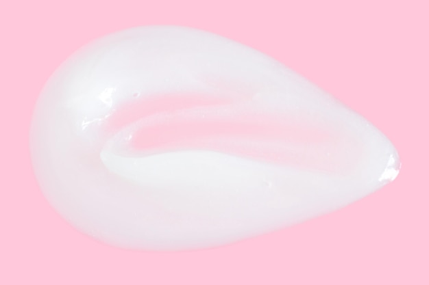 A smear of greasy cream on a pink background