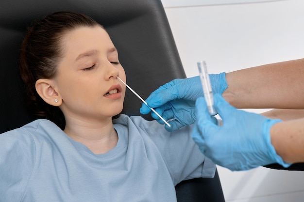 A smear is taken from a little girl's nose for a test