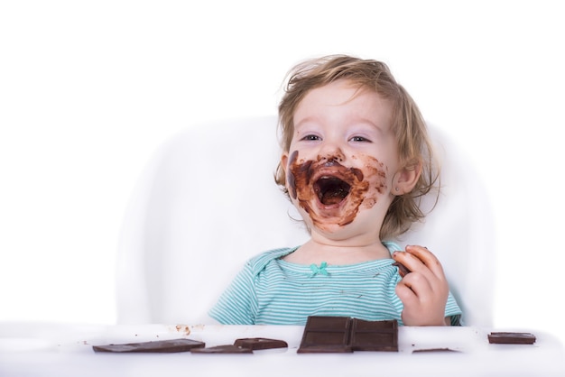 Smeared baby eating chocolate