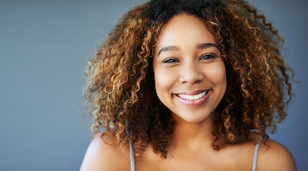 Smile because you can Studio shot of an attractive young woman against a grey background