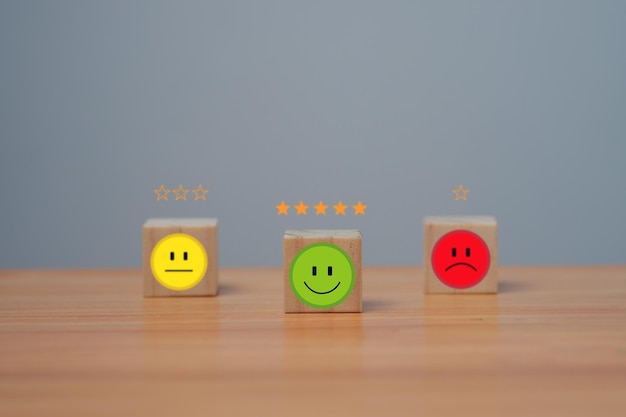 Smile face in bright side and sad face in dark side on wooden block cube for positive mindset selection Customer experience survey and satisfaction feedback concept