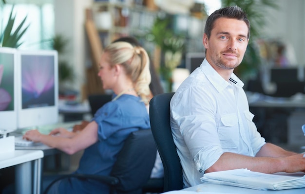 Photo smile happy and businessman working in the office on a creative project with documents professional paperwork and young male designer planning with research information in modern workplace