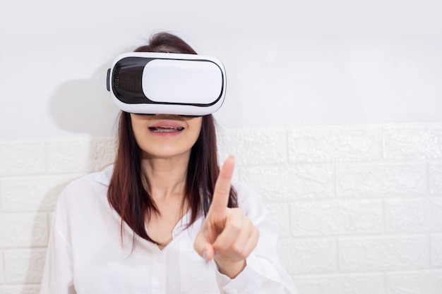 Smile happy woman getting experience using VR-headset glasses of virtual reality at home