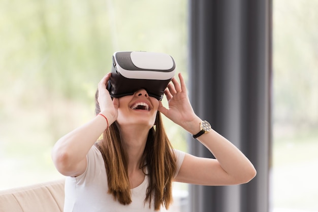 Smile happy woman getting experience using VR-headset glasses of virtual reality at home