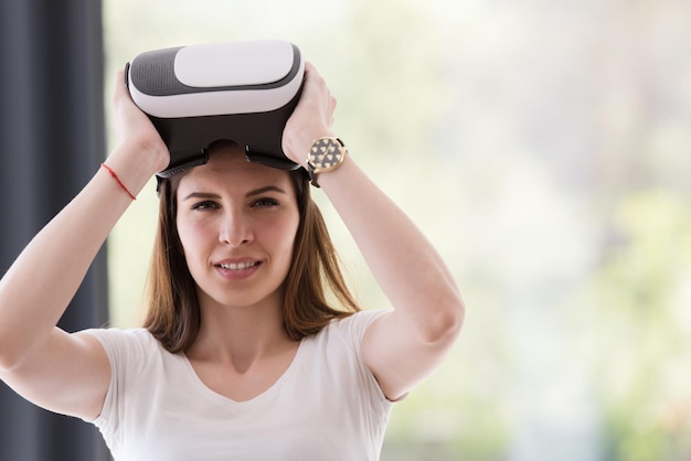 Smile happy woman getting experience using VR-headset glasses of virtual reality at home