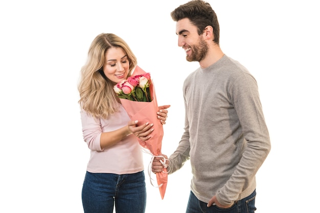 The smile man giving flowers for a woman on the white background