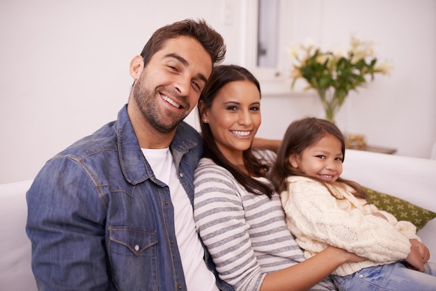 Smile portrait and family with love in living room for support bonding and relaxing together Happy father and mother with daughter for weekend enjoyment care and childhood development at home