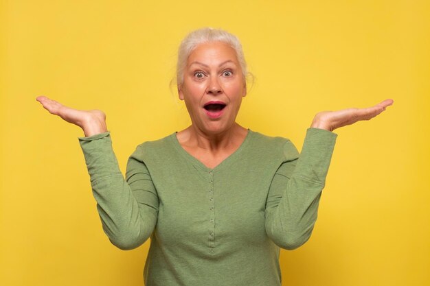 Smile senior woman holding something on open palms