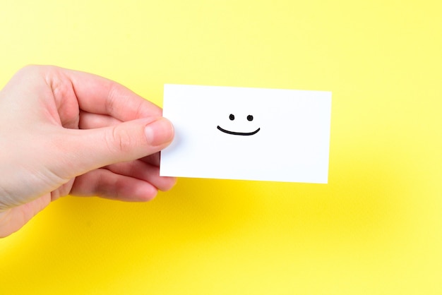 Smile text on a card in woman hand on yellow