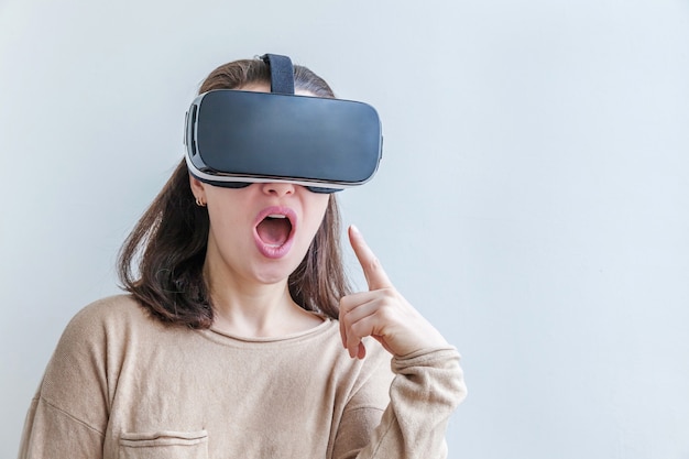 Smile young woman wearing using virtual reality VR glasses helmet headset on white background.