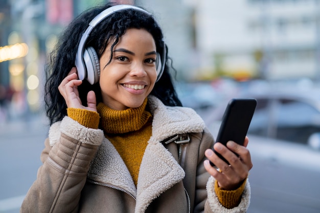 Smiley african american woman listening to music in headphones