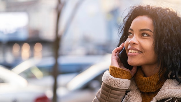 Smiley african american woman talking on the phone with copy space