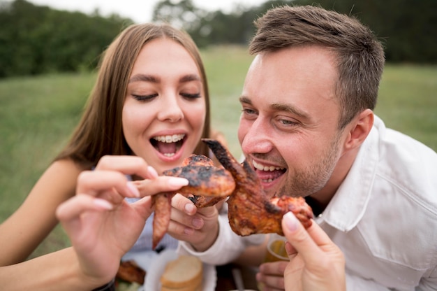 Smiley couple enjoying the food at a barbecue