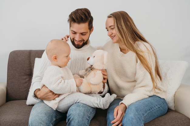 Smiley dad and mom with baby at home