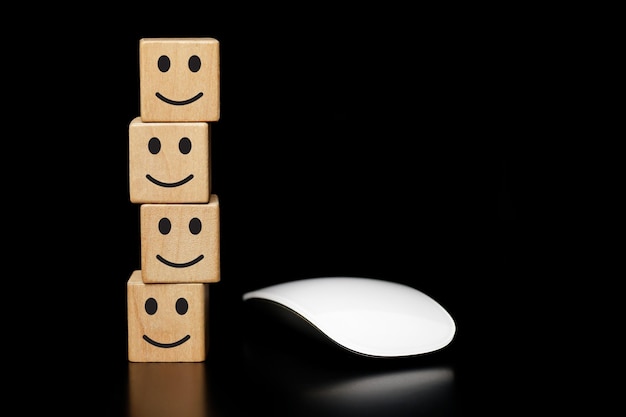 smiley face icon on wooden block with mouse White computer, Satisfaction survey concept.