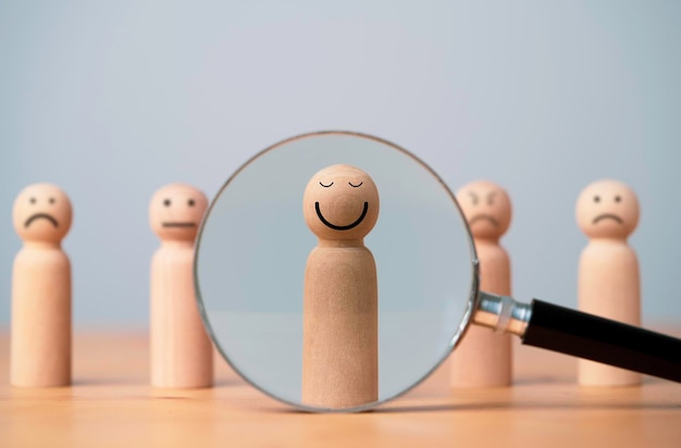 Smiley face on wooden figure with inside magnifier glass for focus of satisfy and happiness of excellent customer evaluation concept