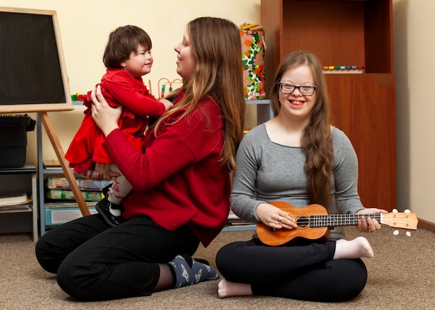 Smiley girl with down syndrome and woman holding child