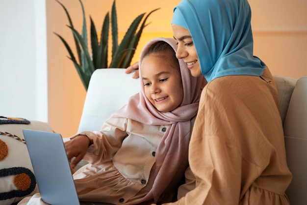 Smiley girl and woman with laptop side view