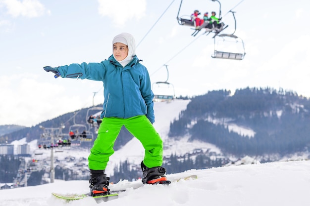 smiley happy little girl with snowboard at winter outdoor