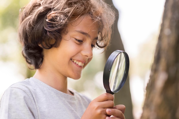 Smiley little boy with magnifier